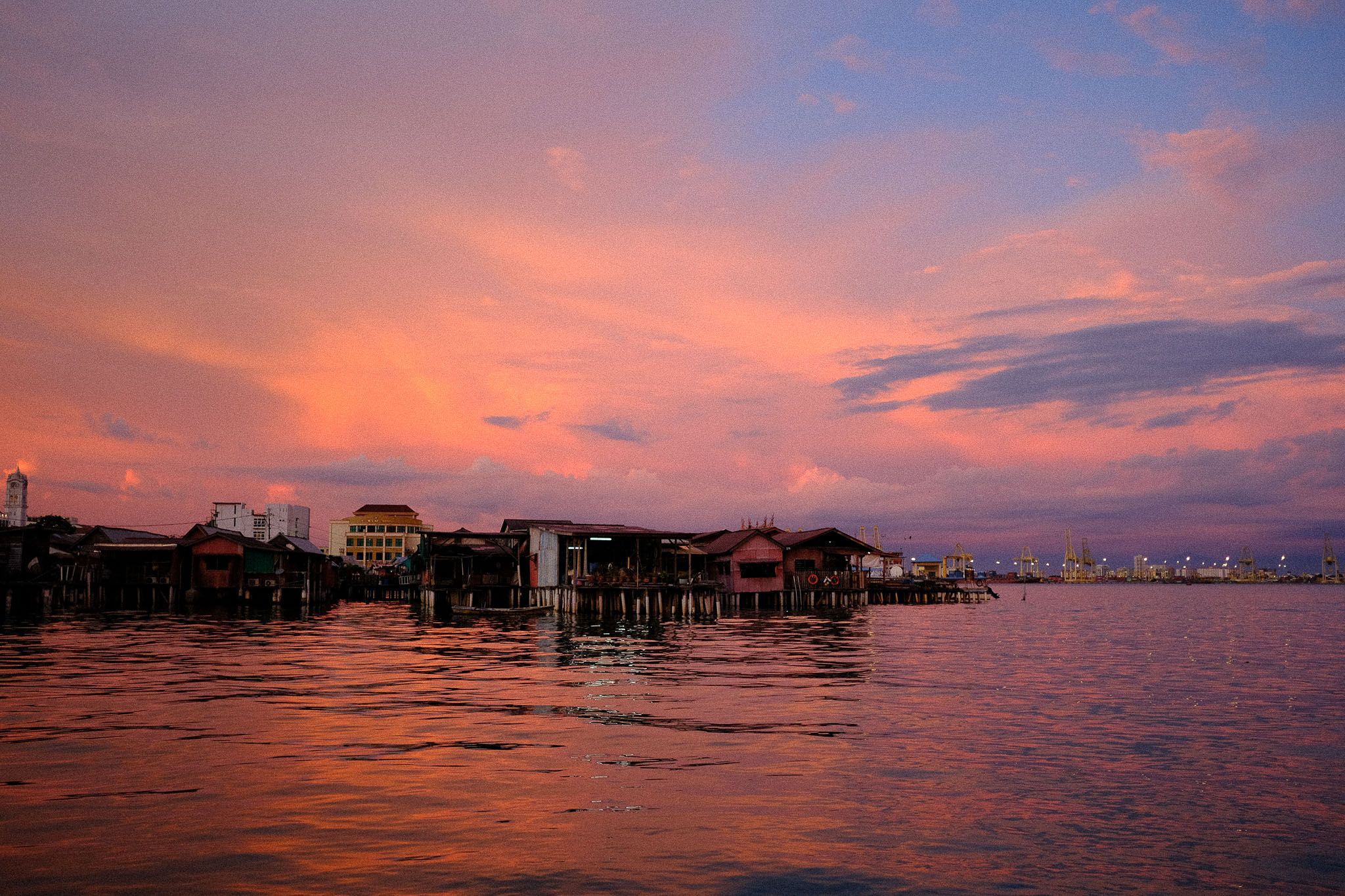 Houses on stilts over the water at sunset